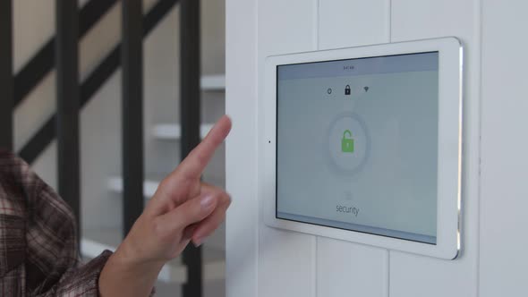 Woman Turning Smart Home Security System On