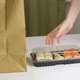Food delivery concept: woman takes out delivered sushi boxes with japanese food. Take away food. - VideoHive Item for Sale