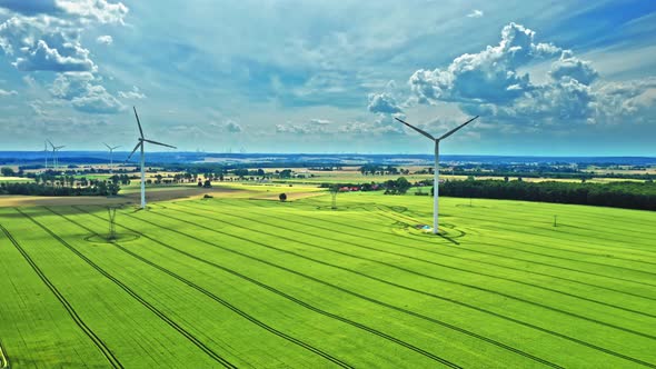 Drone view of wind turbines on green field in summer