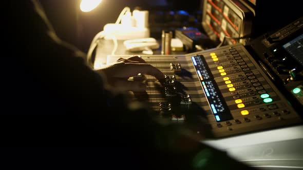 Men's Hands Press the Buttons of the DJ Remote