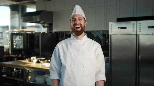 Professional kitchen portrait: Chef laughing and clapping his hands