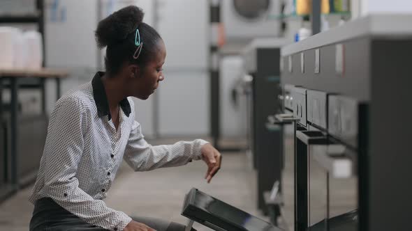 Afroamerican Housewife with Face Mask is Shopping in Home Appliances Store Viewing Stove Inside