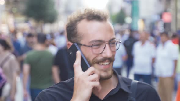 Happy man making phone call on the street.