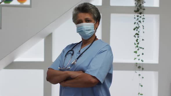 Portrait of senior african american female doctor wearing face mask looking at camera