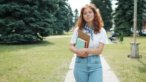 Pretty Redhead Lady Student Walking in Park in Autumn Holding Books Smiling