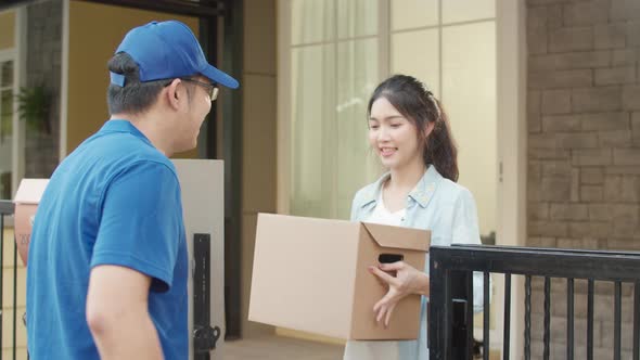 Young postal delivery courier man holding parcel boxes for sending to customer