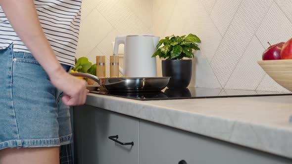 Woman Turn on Induction Hob with Frying Pan