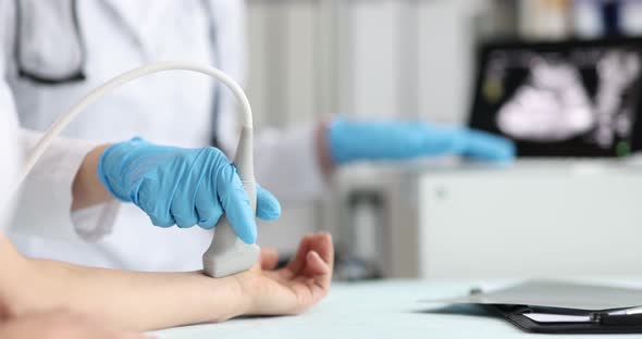 Doctor Doing Ultrasound on Arm in Clinic Closeup