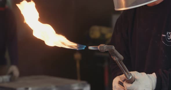 Worker lighting up a tourch in a metal workshop