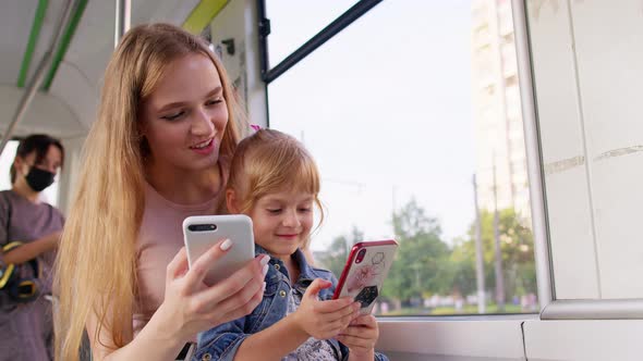 Child Girl with Mother Using Smartphone Chatting Texting in Social Media Public Transport Bus Tram