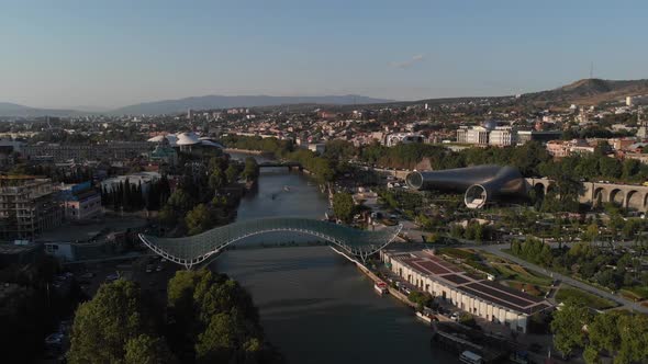 Aerial Shooting of the City Center of Tbilisi in Georgia. Peace Bridge. The Camera Flies a Radius