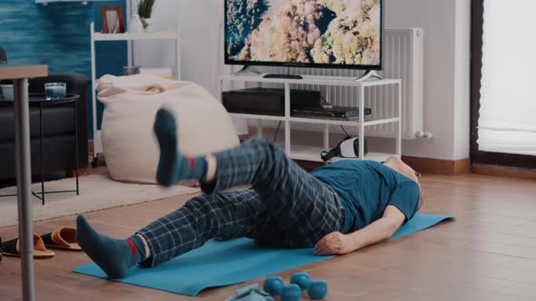 Elder Man Laying on Yoga Mat and Training Muscles