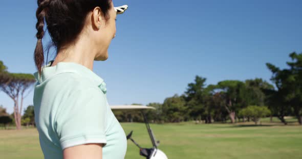 Golfer shielding eyes while standing playing golf