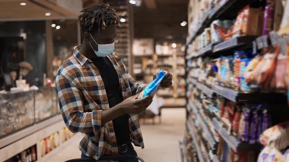 African American Guy Taking Products From the Shelf in the Supermarket
