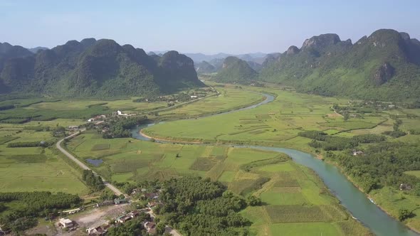 Farmland with Road and River Among Mountains Aerial View