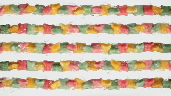 Lot of watered multi-colored sweets, juicy colored chewing marmalade rotates on white background