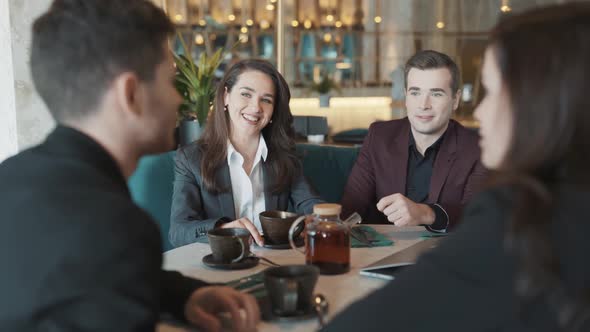 Diverse Group of Business Coworkers Sitting at a Table in Restaurant