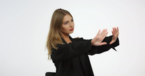 Beautiful Woman in a Black Shirt with Long Blond Hair Looks at Her Manicure