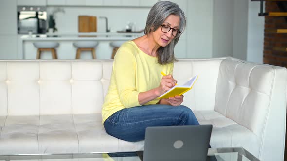 Focused Retired Woman is Learning Online Using a Laptop for Watching Online Classes