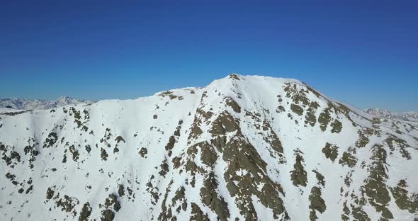 Aerial drone view of snow covered mountains in the winter.