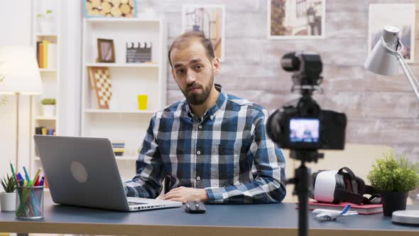 Famous Young Vlogger Typing on Laptop While Talking