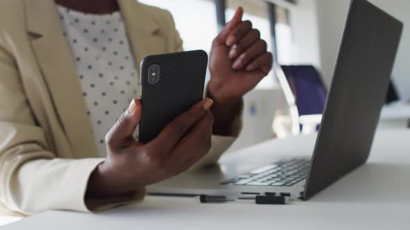 Close up of hands of african american businesswoman using smartphone