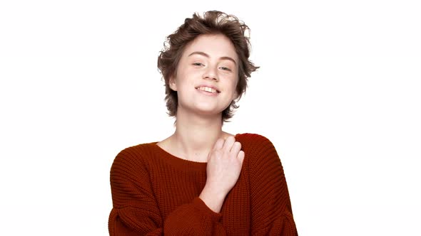 Portrait of Gorgeous Woman in Red Sweater Smiling on Camera with Playful and Flirty Look Isolated