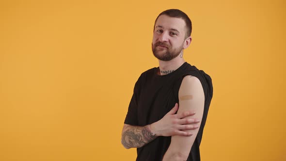 Young Caucasian Millennial Shaking His Head Has Plaster on His Arm with Tattoos on Another Arm