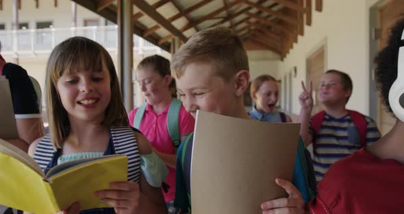 Group of kids with books walking in the school corridor