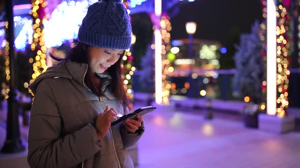 Woman using cellphone at night