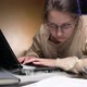 A young woman's old laptop starts to smoke while she is working - VideoHive Item for Sale