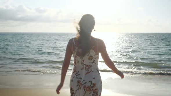 Smiling Woman in Dress Runs Along Empty Sea Beach to Waves