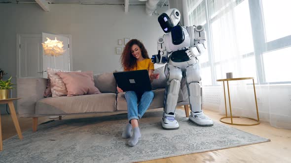 A Cyborg and a Woman Are Talking Over the Laptop. Smart Home Concept.