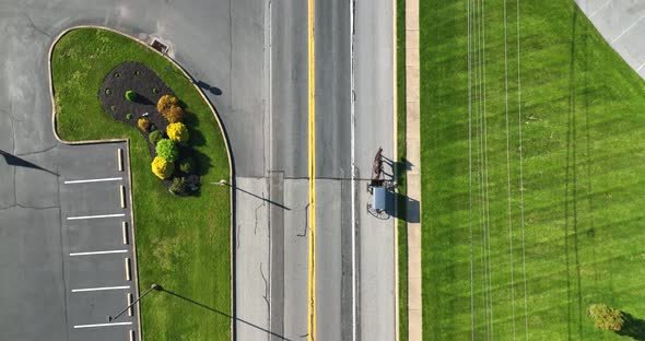 Top down aerial view of Amish horse and buggy. Cars drive by buggy on spring day.