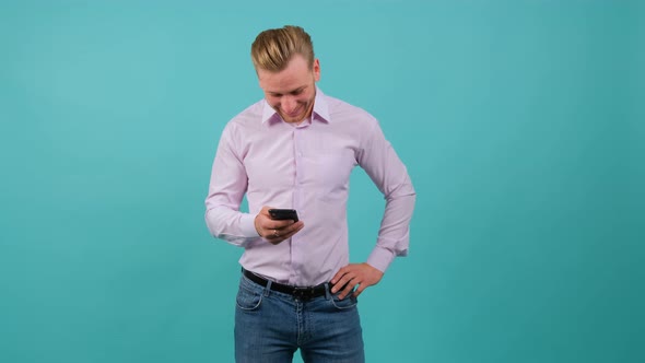 Satisfied Charming Man Watching a Funny Video on Smartphone