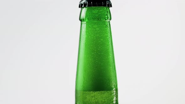 Neck Of A Beer Bottle With Beer Close Up On A White Background, Foamy Beer Inside The Bottle.