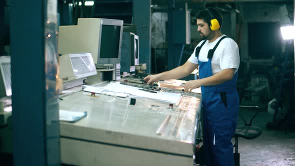 Typography Control Panel and a Male Worker Operating It