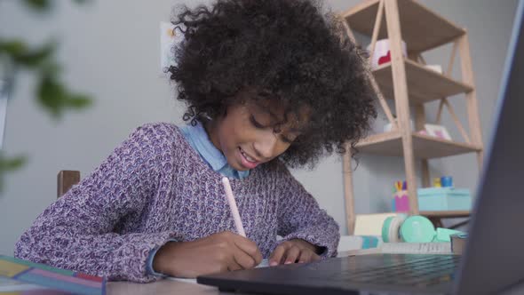Mixed Race Kid Girl Video Calling Learning in Virtual School on Laptop at Home