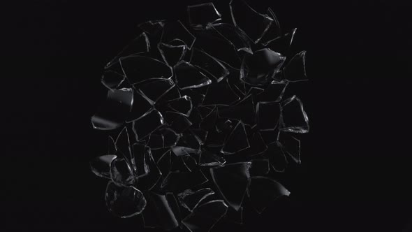 Broken glasses exploding against black background. Slow Motion.