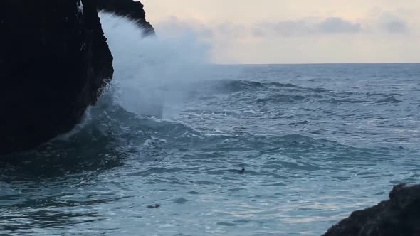 Rough ocean waves crashing on the cliffy coast, in Watamu Beach, Kenya, at dusk