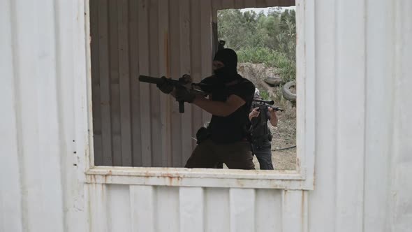 Group of Men with Firearms Seen Running Through Container