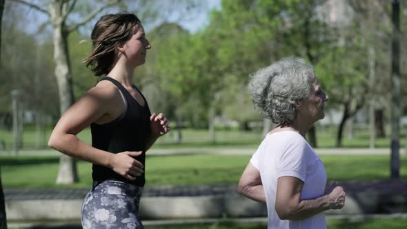 Young and Senior Women in Sportswear Running Together