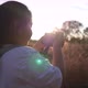 Girl standing in meadow and taking a picture by camera - VideoHive Item for Sale