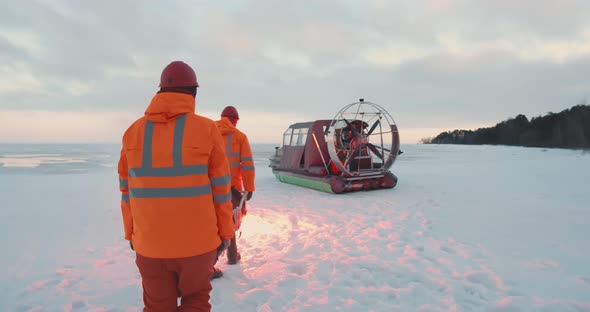 Rescue Service Team Loading Victim on Stretcher in Airboat Patrolling Coast in Winter