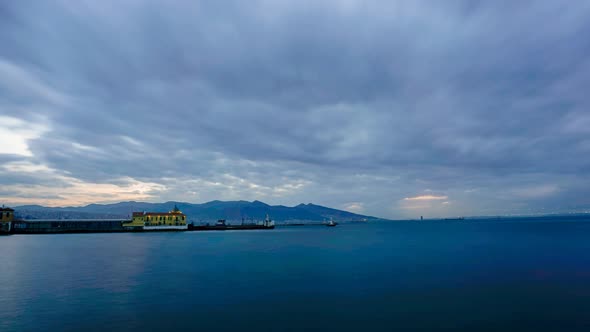 Dreamy cinemagraph of a port on a cloudy and blue day with the ocean and clouds animated in an infin