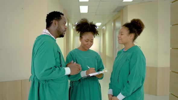 Team of doctors, nurses and assistants have a discussing over document in the hospital together