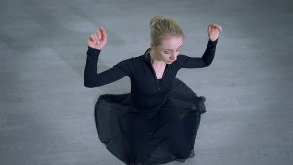 Top View Blond Caucasian Ballerina with Blue Eyes Sitting on Floor Adjusting Hairstyle and Looking