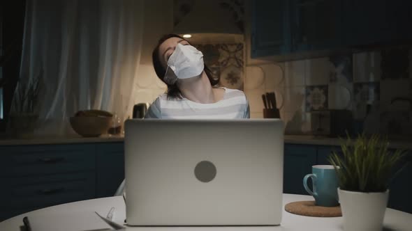 Young Girl In The Kitchen With Laptop. Young Woman Working Remotely At Home Because Of Pandemic