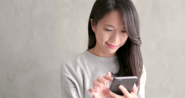 Woman use of smart phone over grey background