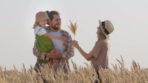 Caring Father Bearded Man Stands in Field in Nature Holding Little Beloved Daughter Girl Child Kid